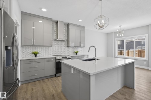 Kitchen featuring gray cabinets, stainless steel appliances, decorative backsplash, and light wood finished floors - 3224 160 Street, Edmonton, AB - Indoor Photo Showing Kitchen With Upgraded Kitchen
