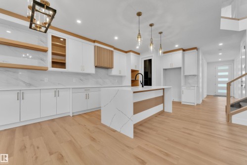 Kitchen with glass fronted cabinets, white cabinets, open shelves, backsplash, and light wood finished floors - 6111 Crawford Drive, Edmonton, AB - Indoor Photo Showing Kitchen With Upgraded Kitchen