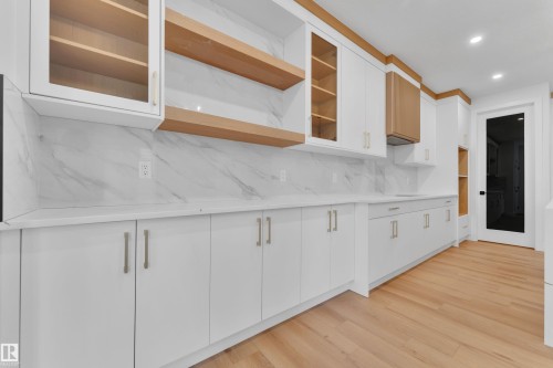Kitchen with white cabinetry, open shelves, glass fronted cabinets, light wood-style floors, and backsplash - 6111 Crawford Drive, Edmonton, AB - Indoor Photo Showing Other Room