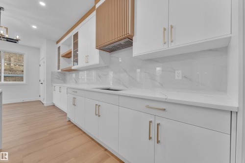 Kitchen with white cabinetry, light wood-style flooring, open shelves, tasteful backsplash, and recessed lighting - 6111 Crawford Drive, Edmonton, AB - Indoor Photo Showing Other Room