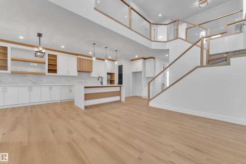 Unfurnished living room with light wood finished floors and suspended lighting - 6111 Crawford Drive, Edmonton, AB - Indoor