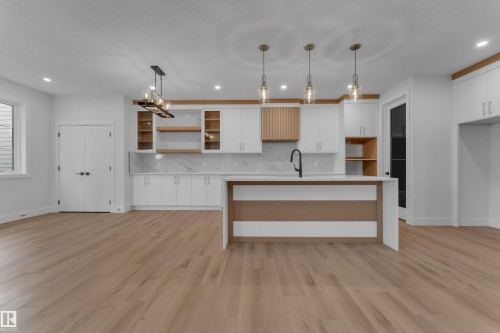 Kitchen with white cabinets, light wood finished floors, and light stone countertops - 6111 Crawford Drive, Edmonton, AB - Indoor Photo Showing Kitchen