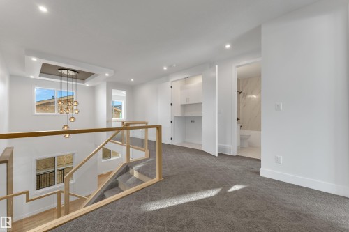 Unfurnished room featuring dark colored carpet, a chandelier, and a raised ceiling - 6111 Crawford Drive, Edmonton, AB - Indoor Photo Showing Other Room