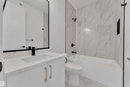 Bathroom featuring bathtub / shower combination, vanity, and marble look tiles - 6111 Crawford Drive, Edmonton, AB - Indoor Photo Showing Bathroom