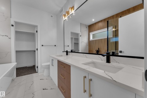 Bathroom with double vanity, a soaking tub, a walk in closet, recessed lighting, and a shower with door - 6111 Crawford Drive, Edmonton, AB - Indoor
