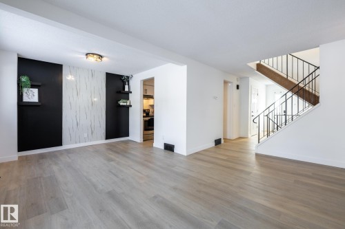 Unfurnished living room featuring an accent wall and light wood-type flooring - 13449 40 Street, Edmonton, AB - Indoor