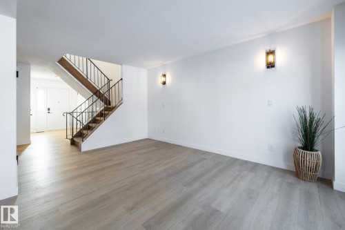 Unfurnished living room with stairs and light wood-style flooring - 13449 40 Street, Edmonton, AB - Indoor Photo Showing Other Room