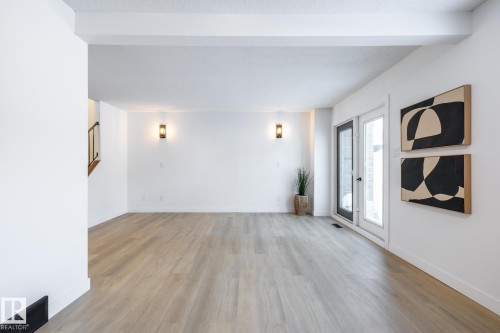 Unfurnished living room featuring light wood-style flooring and baseboards - 13449 40 Street, Edmonton, AB - Indoor