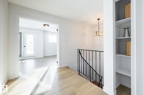 Corridor featuring light wood-type flooring, an upstairs landing, and built in features - 13449 40 Street, Edmonton, AB - Indoor Photo Showing Other Room