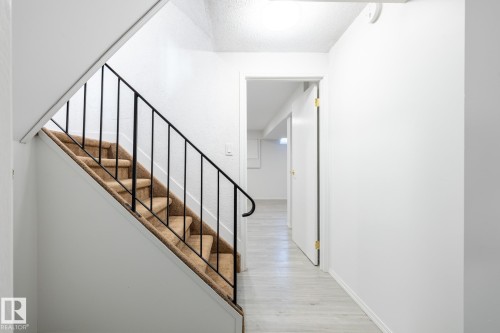 Stairs featuring wood finished floors and a textured ceiling - 13449 40 Street, Edmonton, AB - Indoor Photo Showing Other Room