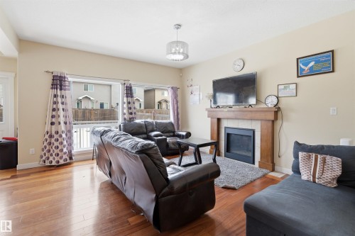 Living room featuring hardwood / wood-style flooring and a tiled fireplace - 2923 16 Street, Edmonton, AB - Indoor Photo Showing Living Room With Fireplace