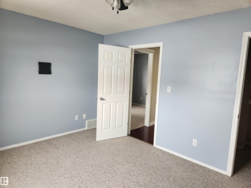 Unfurnished bedroom with carpet floors, a textured ceiling, and ceiling fan - 14076 152 Avenue, Edmonton, AB - Indoor
