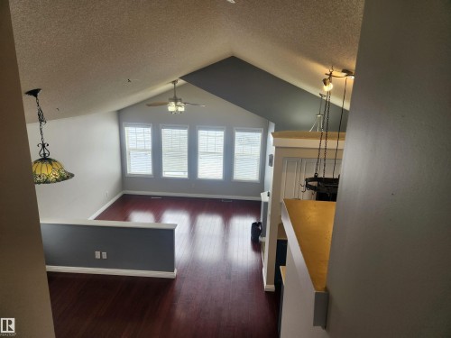 Unfurnished living room with dark wood-type flooring, a textured ceiling, and ceiling fan - 14076 152 Avenue, Edmonton, AB - Indoor Photo Showing Other Room