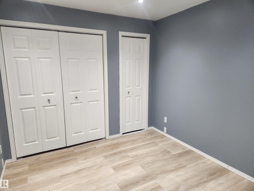 Unfurnished bedroom with multiple closets and light wood-type flooring - 14076 152 Avenue, Edmonton, AB - Indoor Photo Showing Other Room