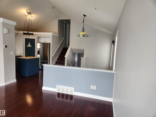 Interior space featuring wood-type flooring and a textured ceiling - 14076 152 Avenue, Edmonton, AB - Indoor