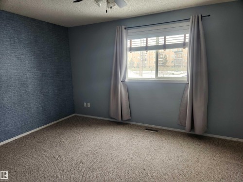 Unfurnished room with wallpapered walls, carpet, ceiling fan, a textured ceiling, and an accent wall - 14076 152 Avenue, Edmonton, AB - Indoor Photo Showing Other Room