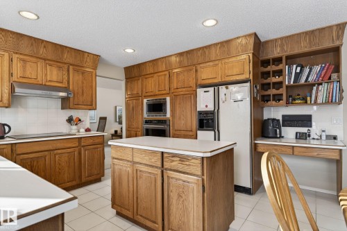 Kitchen featuring wood finish cabinetry, tasteful backsplash, light countertops, and recessed lighting - 313 Hedley Way, Edmonton, AB - Indoor Photo Showing Kitchen