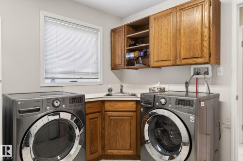 Laundry area featuring cabinet space and separate washer and dryer - 313 Hedley Way, Edmonton, AB - Indoor Photo Showing Laundry Room