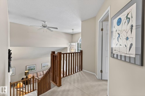 Hall featuring an upstairs landing, light carpet, and a textured ceiling - 313 Hedley Way, Edmonton, AB - Indoor Photo Showing Other Room