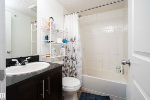 Bathroom with a textured ceiling, shower / bath combo, and vanity - 415 111 Watt Common, Edmonton, AB - Indoor Photo Showing Bathroom