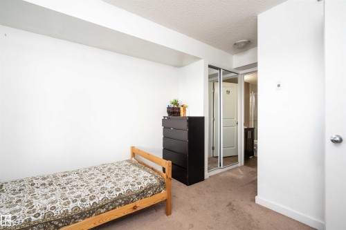 Carpeted bedroom with a closet and a textured ceiling - 415 111 Watt Common, Edmonton, AB - Indoor Photo Showing Bedroom