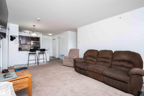 Living room with a textured ceiling and light carpet - 415 111 Watt Common, Edmonton, AB - Indoor Photo Showing Living Room
