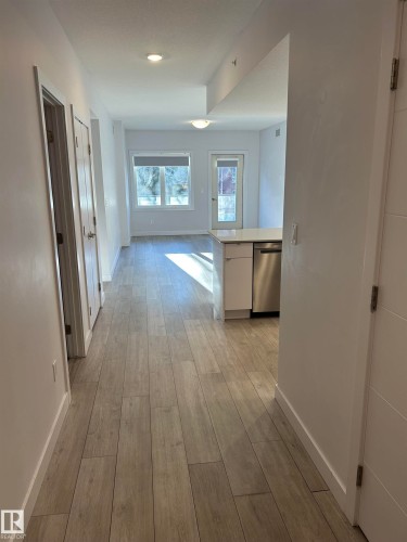 Corridor featuring baseboards and light wood finished floors - 202 8510 90 Street, Edmonton, AB - Indoor Photo Showing Other Room