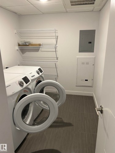 Laundry area featuring electric panel and washing machine and clothes dryer - 202 8510 90 Street, Edmonton, AB - Indoor Photo Showing Laundry Room