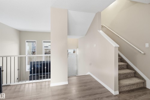 Staircase with wood finished floors and baseboards - 48 1140 Chappelle Boulevard, Edmonton, AB - Indoor Photo Showing Other Room