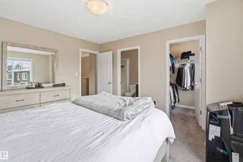 Bedroom with light carpet, a walk in closet, and connected bathroom - 48 1140 Chappelle Boulevard, Edmonton, AB - Indoor Photo Showing Bedroom