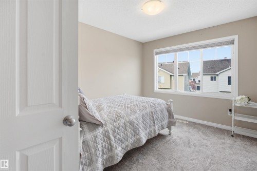 Carpeted bedroom featuring baseboards and a textured ceiling - 48 1140 Chappelle Boulevard, Edmonton, AB - Indoor Photo Showing Bedroom