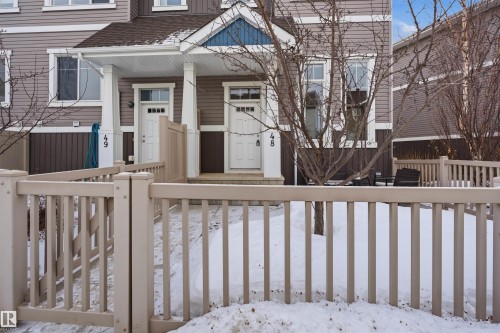 Snow covered property entrance with a porch and a shingled roof - 48 1140 Chappelle Boulevard, Edmonton, AB - Outdoor
