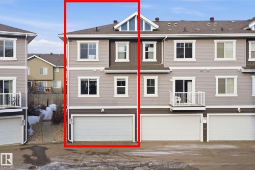 Back of property with a balcony, an attached garage, a residential view, roof with shingles, and driveway - 48 1140 Chappelle Boulevard, Edmonton, AB - Outdoor With Facade