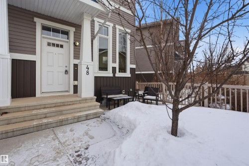 Snow covered property entrance with board and batten siding - 48 1140 Chappelle Boulevard, Edmonton, AB - Outdoor