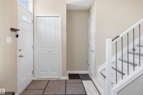 Foyer entrance featuring stairway and baseboards - 48 1140 Chappelle Boulevard, Edmonton, AB - Indoor Photo Showing Other Room