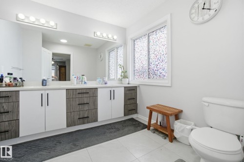 Bathroom with double vanity, ceiling fan, and dark tile patterned flooring - 1532 37C Avenue, Edmonton, AB - Indoor Photo Showing Bathroom
