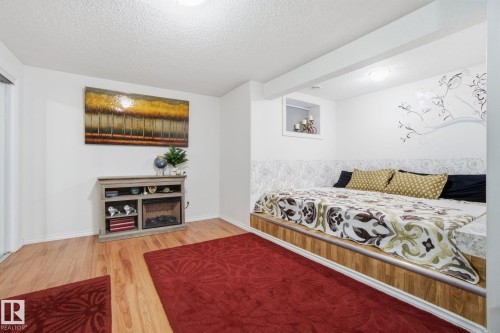 Bedroom with light wood-style flooring and a textured ceiling - 1532 37C Avenue, Edmonton, AB - Indoor