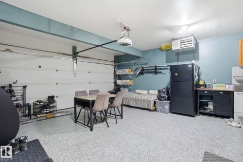 Garage featuring freestanding refrigerator, a heating unit, and a garage door opener - 1532 37C Avenue, Edmonton, AB - Indoor Photo Showing Garage