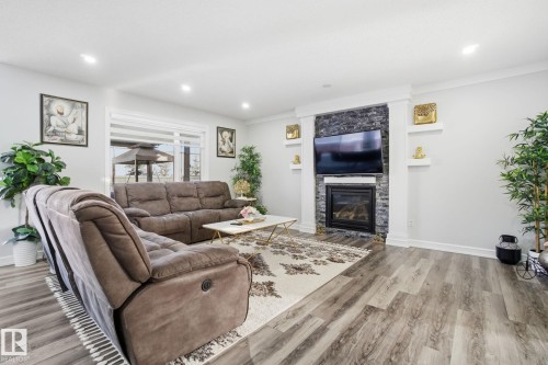 Living room featuring light wood finished floors, a glass covered fireplace, and recessed lighting - 1532 37C Avenue, Edmonton, AB - Indoor Photo Showing Living Room With Fireplace