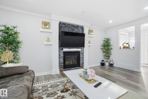 Living area featuring light wood-style flooring, a stone fireplace, and recessed lighting - 1532 37C Avenue, Edmonton, AB - Indoor Photo Showing Living Room With Fireplace