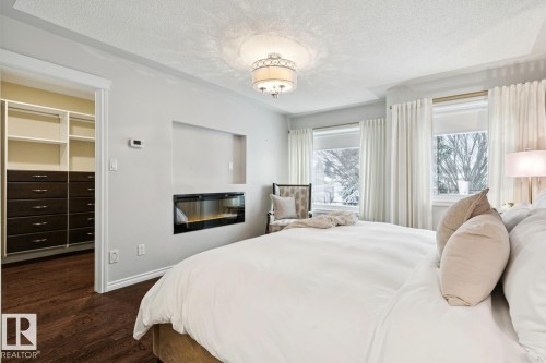 22 Prestige Point(E), Edmonton, AB - Indoor Photo Showing Bedroom With Fireplace