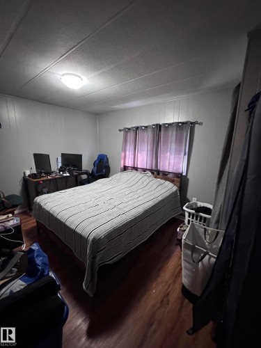 Bedroom featuring wood finished floors - #44 9501 104 Ave, Westlock, AB - Indoor Photo Showing Bedroom