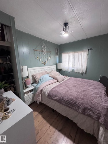 Bedroom featuring hardwood / wood-style floors, a textured ceiling, and a ceiling fan - #44 9501 104 Ave, Westlock, AB - Indoor Photo Showing Bedroom