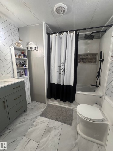 Bathroom featuring vanity, light marble finish floors, and shower / tub combo with curtain - #44 9501 104 Ave, Westlock, AB - Indoor Photo Showing Bathroom