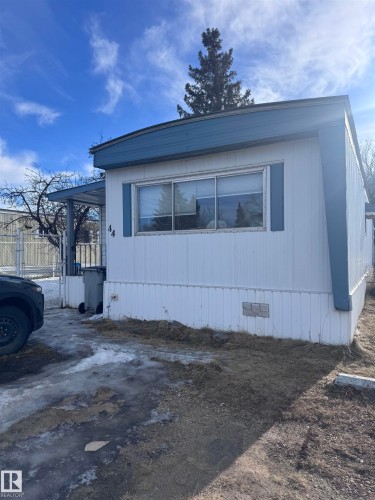 View of property exterior featuring crawl space and a gate - #44 9501 104 Ave, Westlock, AB - Outdoor