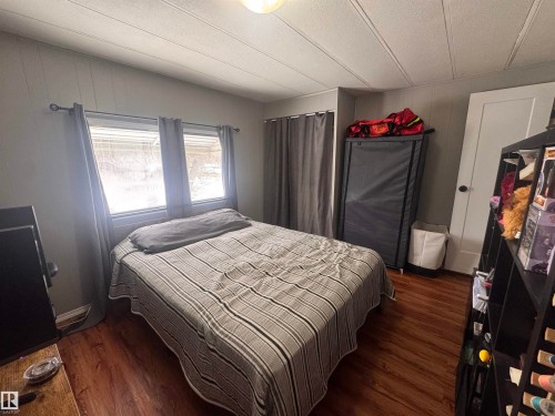 Bedroom featuring dark wood-type flooring - #44 9501 104 Ave, Westlock, AB - Indoor Photo Showing Bedroom