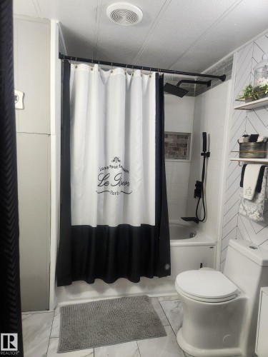 Full bath featuring a textured ceiling and shower / tub combo - #44 9501 104 Ave, Westlock, AB - Indoor Photo Showing Bathroom