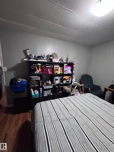 Bedroom with wood finished floors - #44 9501 104 Ave, Westlock, AB - Indoor Photo Showing Bedroom