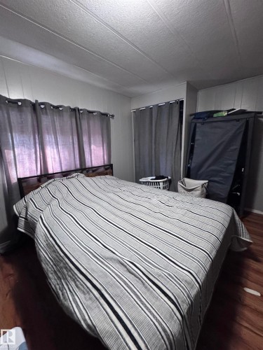 Bedroom with dark wood finished floors and a textured ceiling - #44 9501 104 Ave, Westlock, AB - Indoor Photo Showing Bedroom