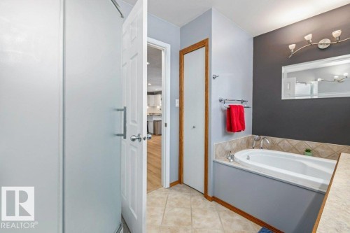 Full bath featuring a bath and light tile patterned floors - 1 Larkspur Crescent, St. Albert, AB - Indoor Photo Showing Bathroom